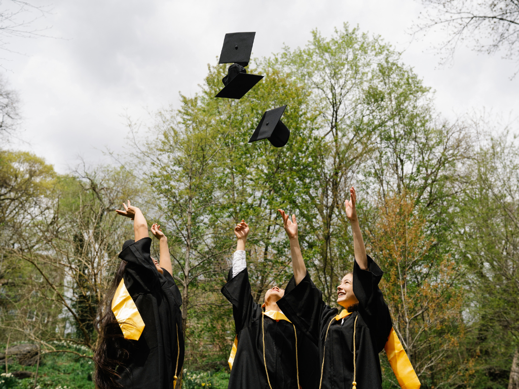 Graduates throwing cap in the air