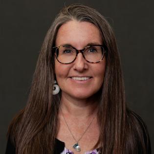 Caucasian woman with glasses and brown hair.