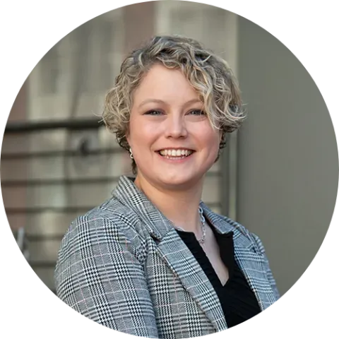 Caucasian woman with short blond, curly hair.