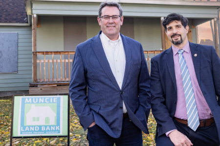 Ball Brothers Foundation President/CEO Jud Fisher (left) and 2024 Fisher Governance Award recipient John West stand outside a Muncie Land Bank property. West was honored for his exceptional board leadership advancing neighborhood revitalization efforts across the community.