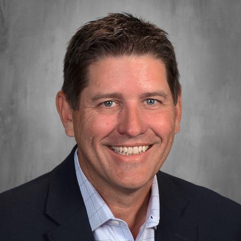 Caucasian man with brown hair and navy jacket