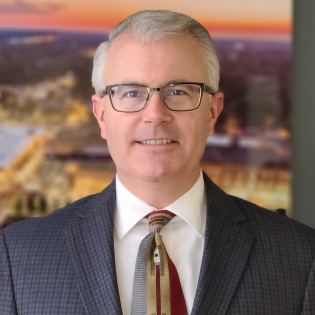 Caucasian man with glasses wearing suit and tie
