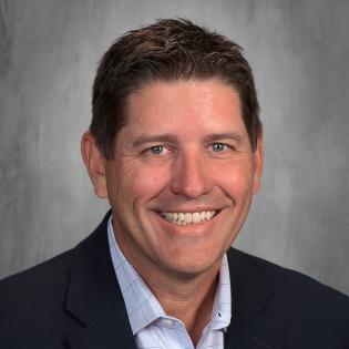 Caucasian man with brown hair and navy jacket