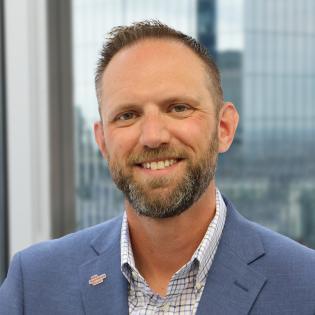 Caucasian man with beard wearing a blue suit jacket