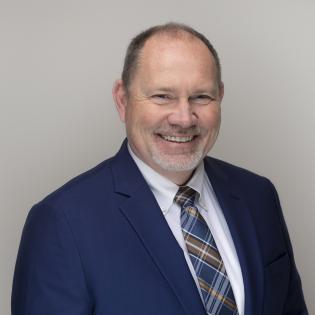 Caucasian man with navy suit.
