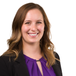 A woman wearing a purple shirt and black jacket